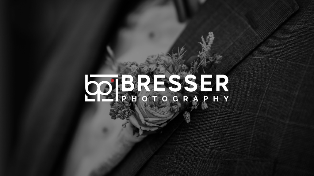 Der Blumenschmuck an einem Sakko eines Bräutigams. Ein Foto in schwarz weiß samt Firmenlogo. Hochzeitsfotograf aus Neuss - Bresser-Photography