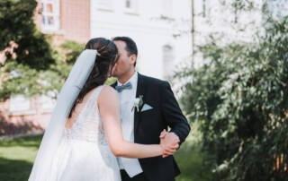 Ein Hochzeitspaar genießt die ersten Momente nach der Trauung und küsst sich. Dabei werden Brautpaarfotos von einem erfahrenen Hochzeitsfotografen aus Neuss gefertigt.