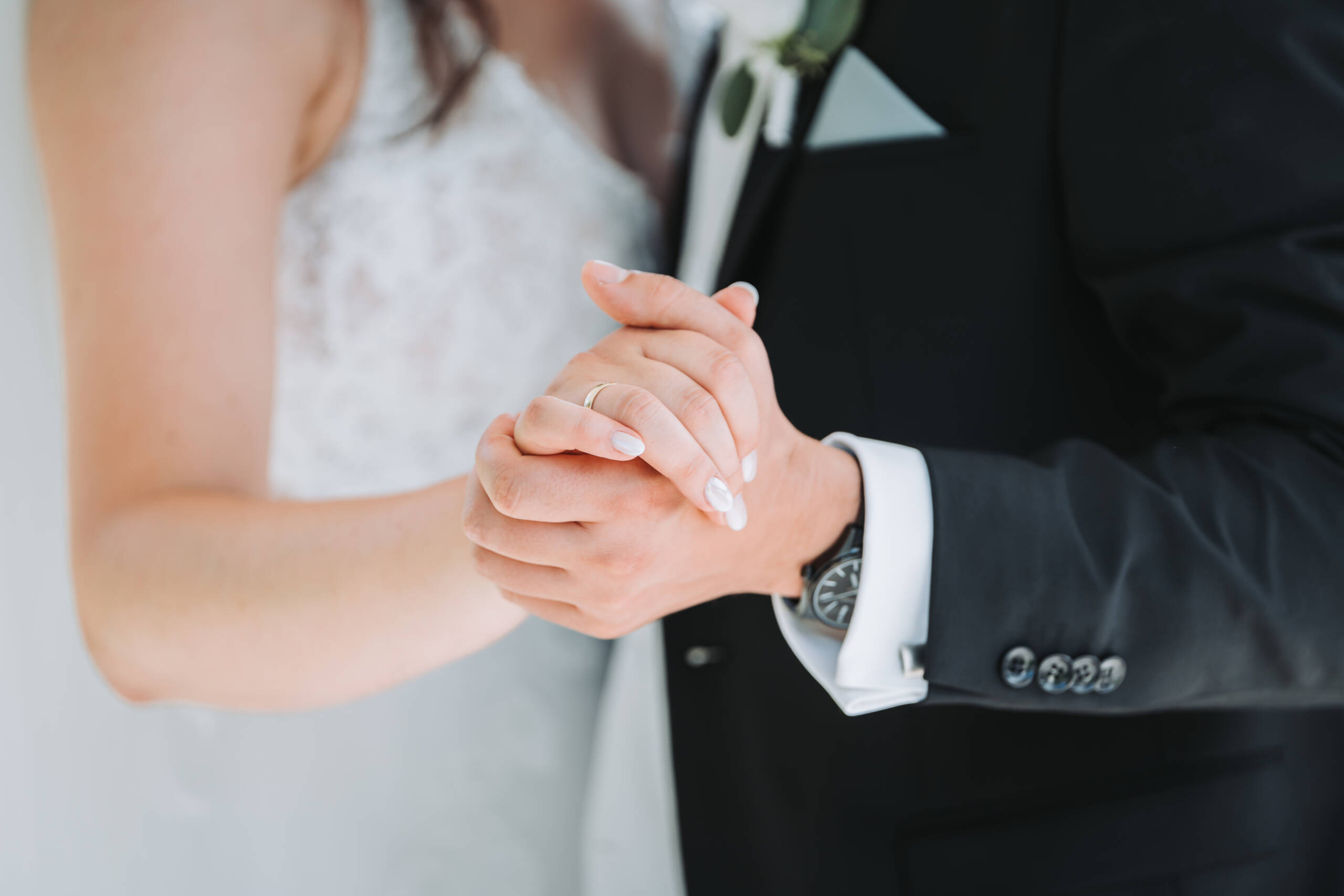 Ein Brautpaar führt den ersten Hochzeitstanz aus und hält sich dabei an den Händen fest.