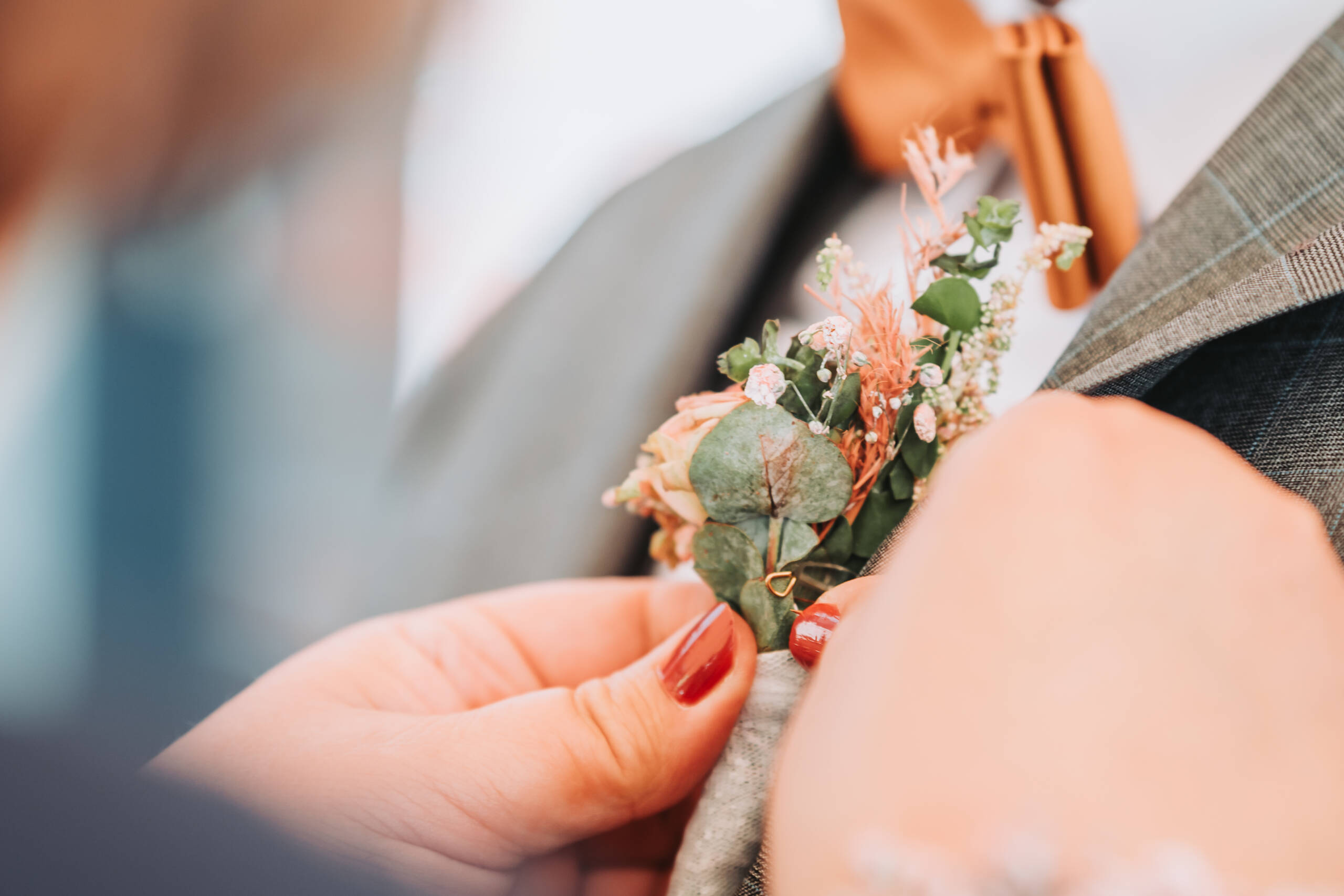 Eine Schwiegermutter richtet den Blumenschmuck am Sakko des Bräutigams - Hochzeitsfotograf aus Neuss - Bresser-Photography