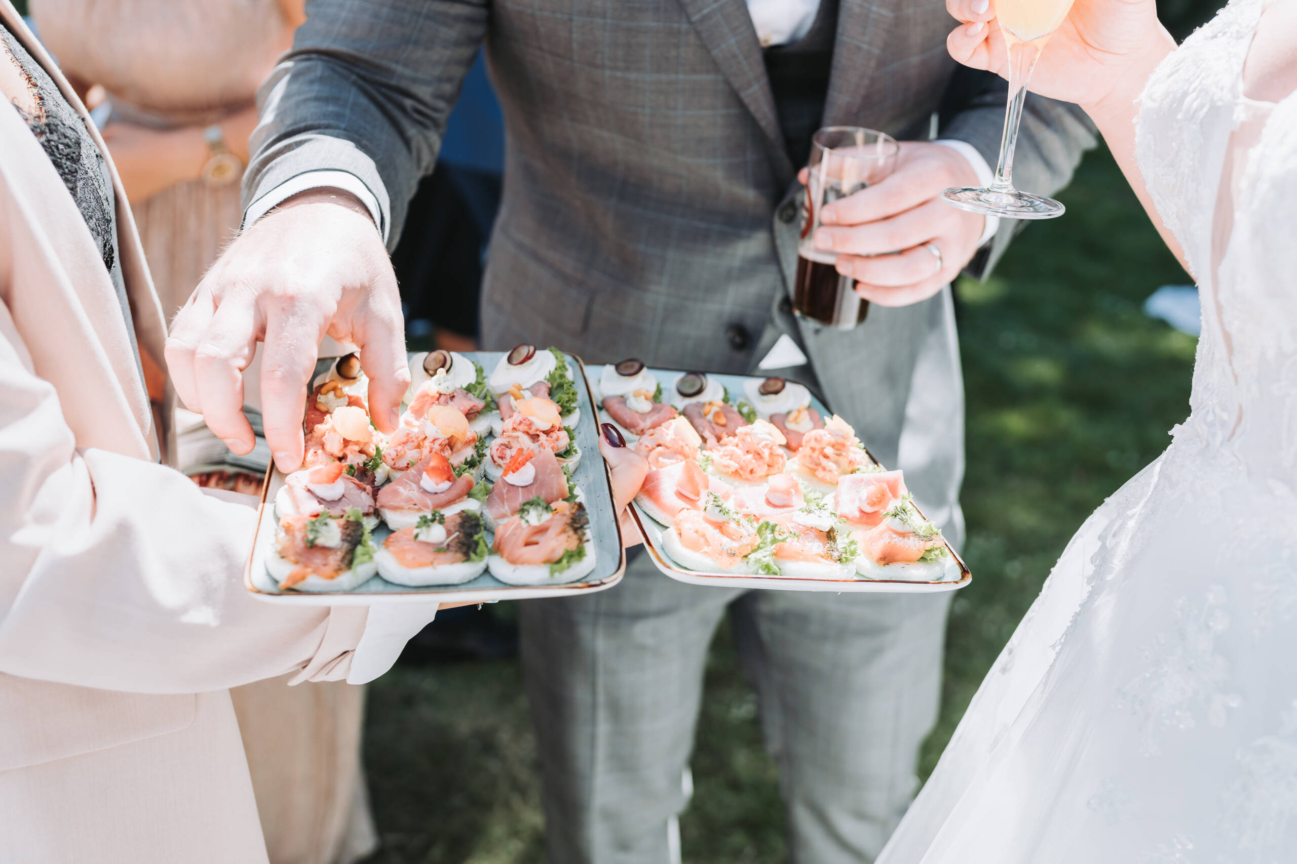 Ein Bräutigam nimmt Snacks von einem Tablett auf einer Hochzeit. Bresser-Photography - Hochzeitsfotograf Neuss - Hochzeit - Hochzeitsfotos